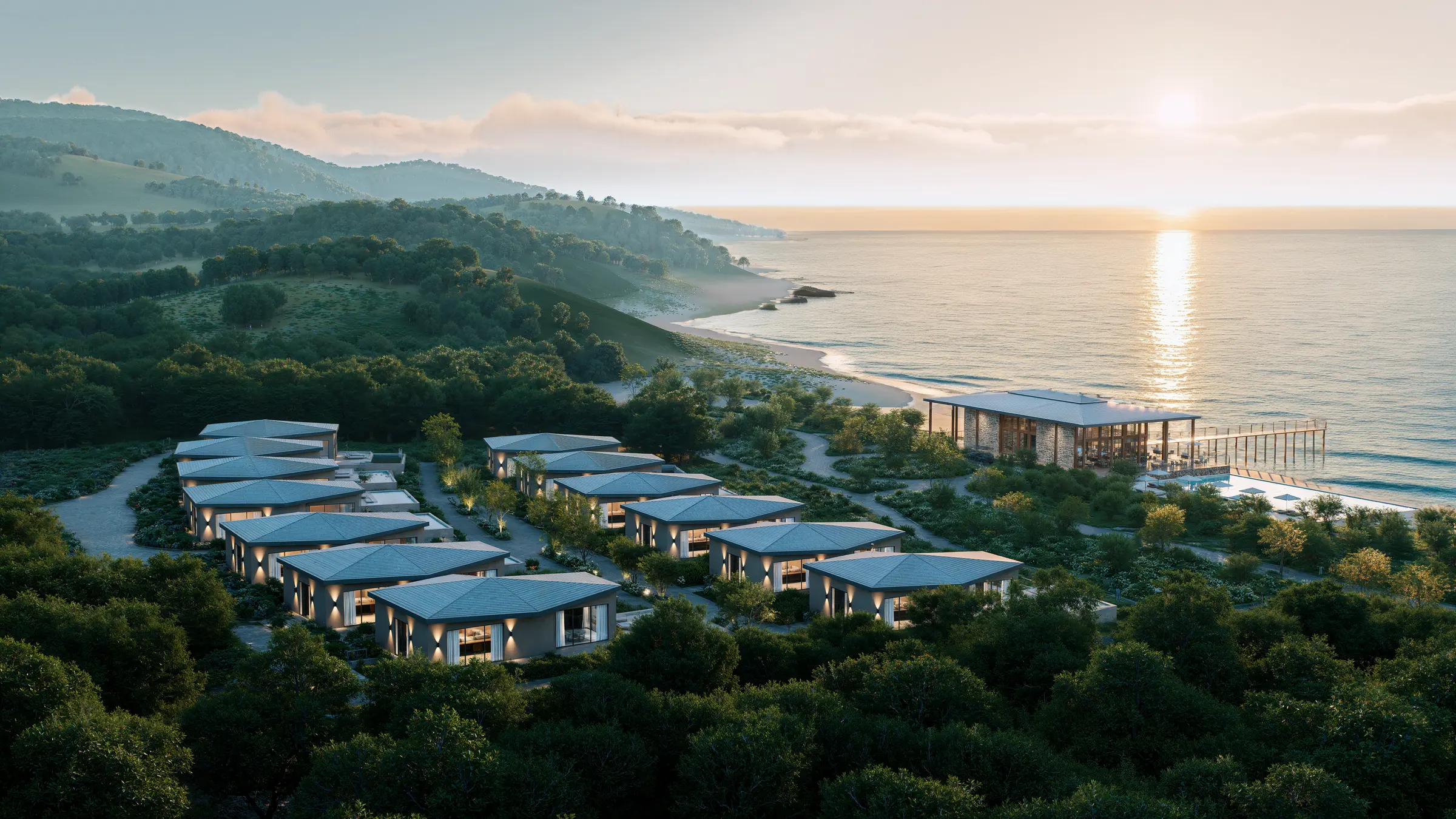 Coastal villa resort and beach pavilion seen from the air at sunset