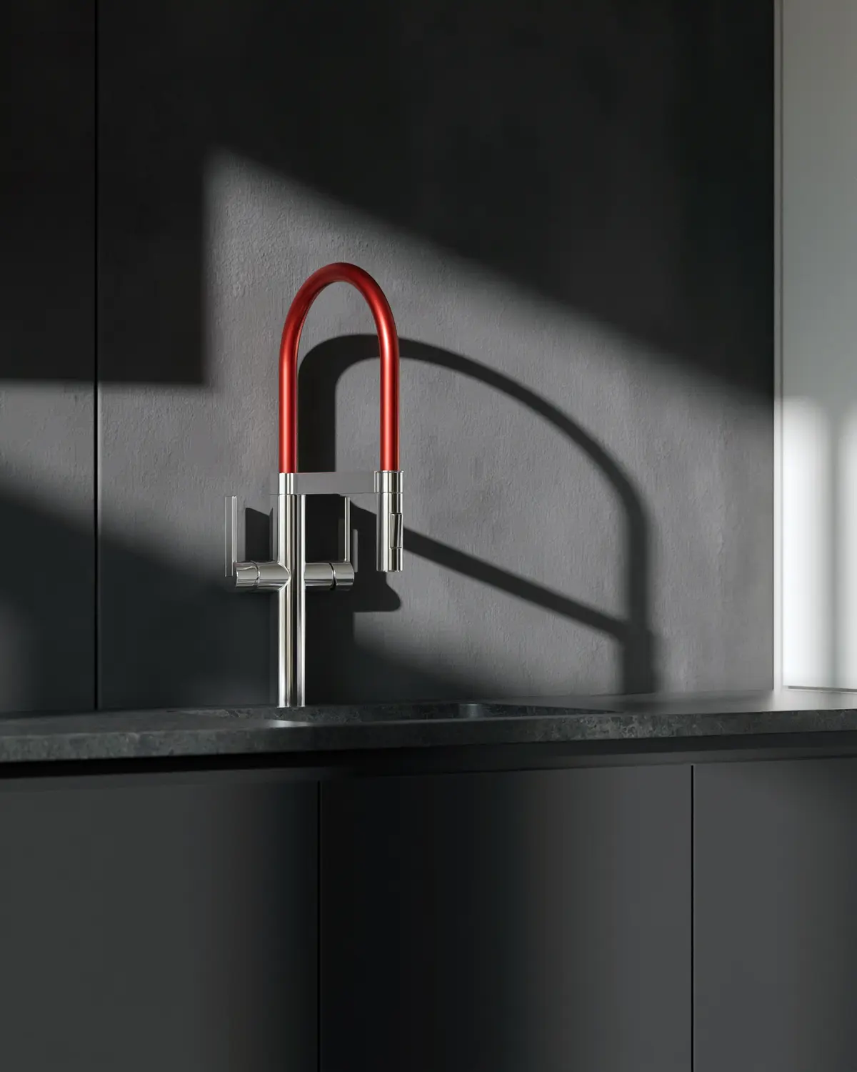 Close-up of a red and chrome kitchen tap on a dark stone counter