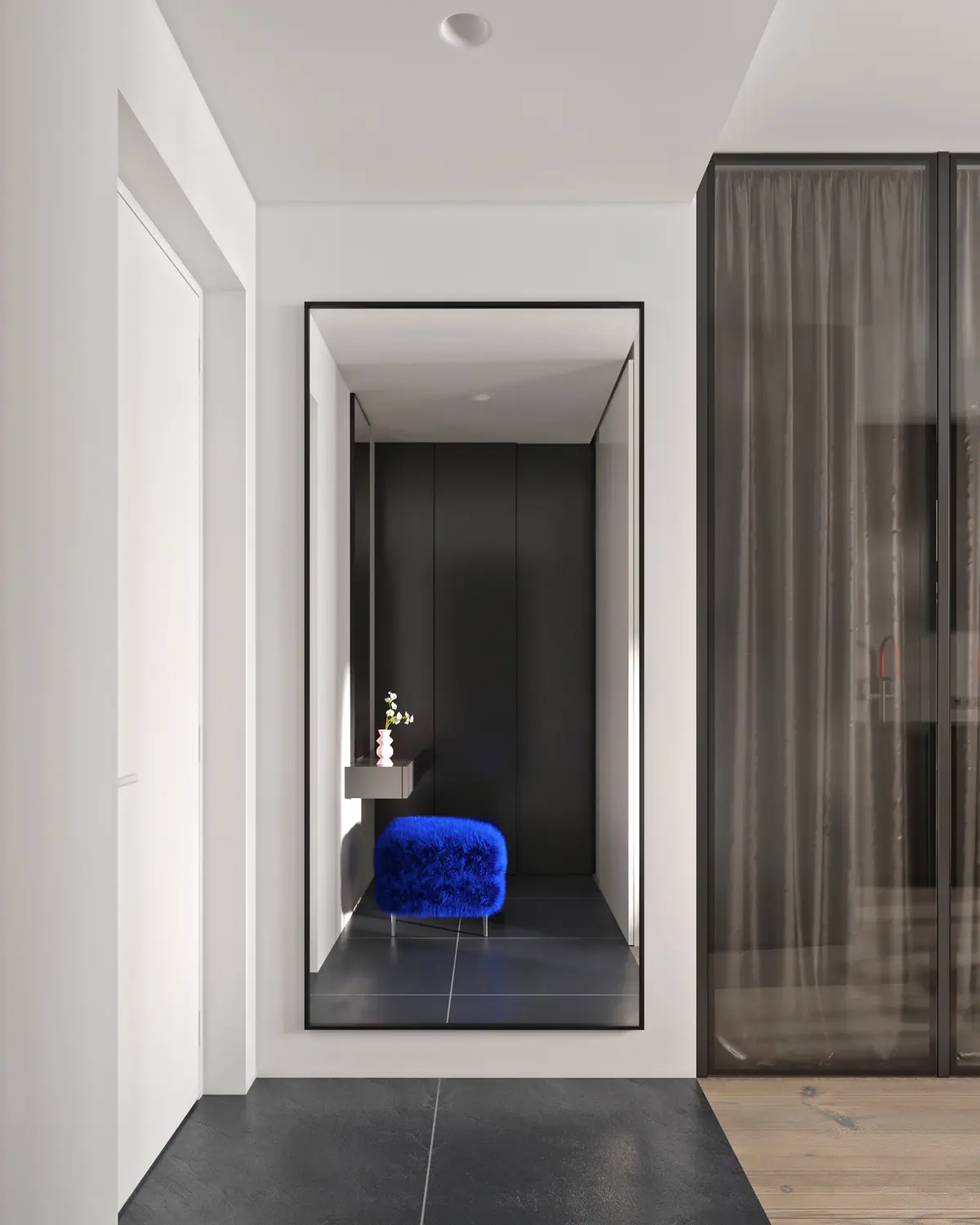 Minimal white entry hall with a blue velvet stool and a mirrored niche